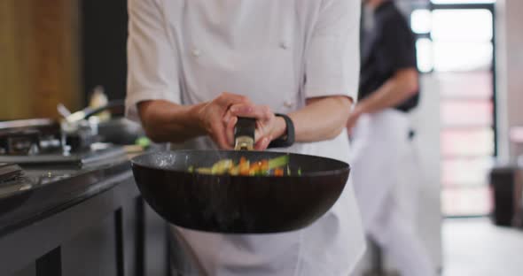 Caucasian female chef teaching diverse group preparing dishes and smiling