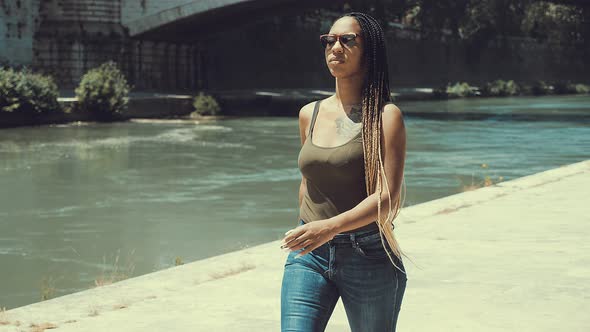 thoughtful afro american woman walking by the Tiber absorbed in her thoughts