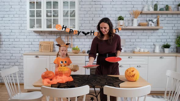 Daughter Helping Mother To Prepare for Halloween