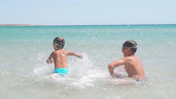 Children, Boys Have Fun at Sea in the Open Air. Happy and Joyous Boys Play in the Purest Sea. Summer
