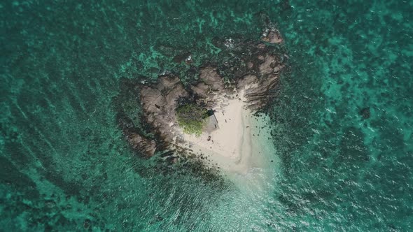 Small Wild Island Aerial Top Down View with Ocean Turquoise Waves Coral Reef Around