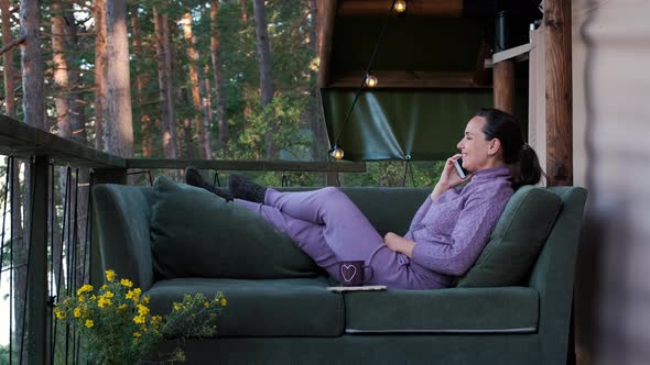 Woman Talking on Phone Outside Glamping Tent