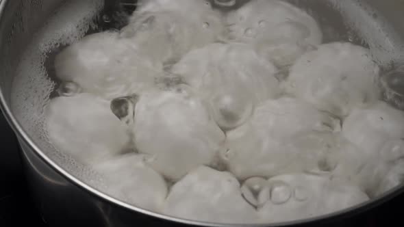 White Chicken Eggs Boiling in Stainless Steel Pan