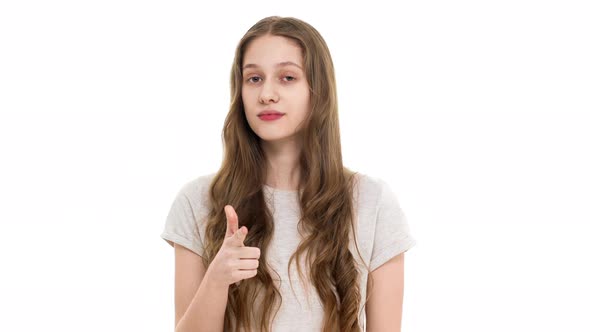 Portrait of Attractive Schoolgirl 17y in Casual Tshirt Gesturing Finger on Camera Meaning Hey you