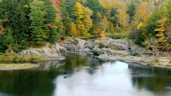 People at Dog Head falls in Johnson Vermont in the fall during foliage via 4k drone footage