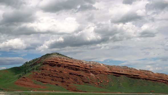 Time lapse of clouds moving over red dirt hillside in Wyoming