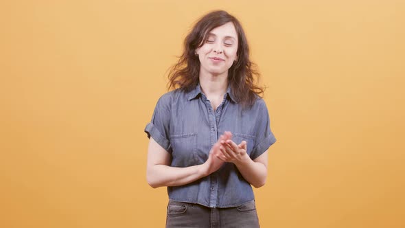 Pretty Woman Applauding Over Yellow Background