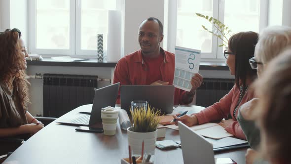 Cheerful African American Man Presenting Business Plan to Team