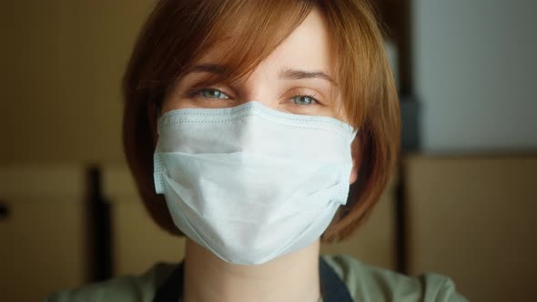 Closeup of Smiling Businesswoman Wearing Face Mask in Small Warehouse