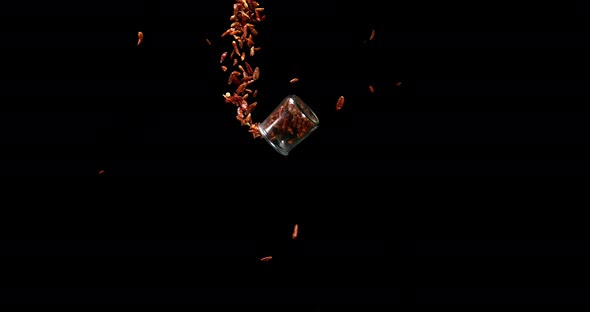 Cayenne Chili Pepper, capsicum frutescens, spice falling against Black Background, Slow Motion 4K