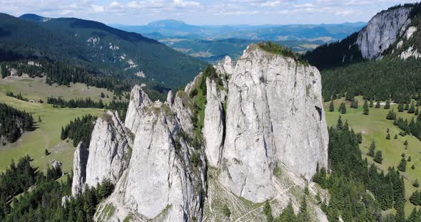 The Lonely Rock Jagged Cliffs With Lush Evergreen Forest At Piatra Singuratica