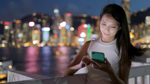 Woman using cellphone at night