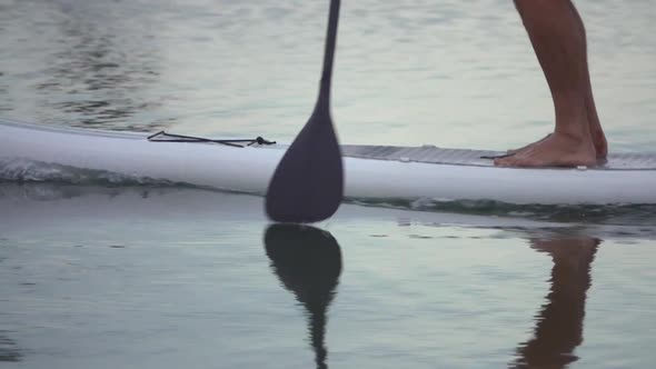 Extreme close up detail view of a man paddling his SUP stand-up paddleboard.