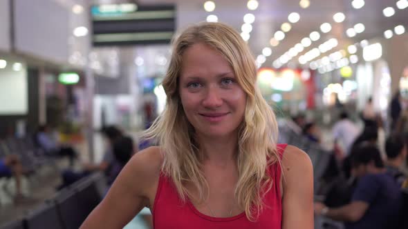 Young Beautiful Woman in the Waiting Room of the Airport or Train Station