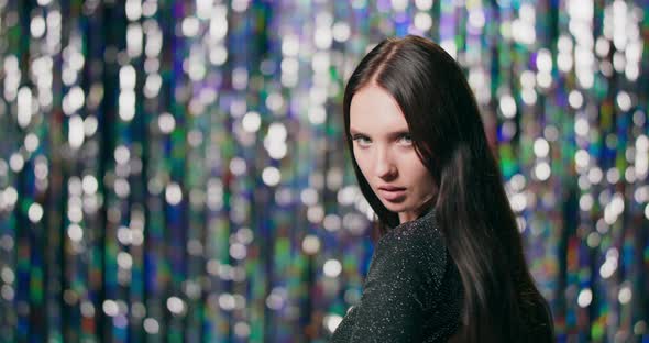 Closeup of a Brunette Girl Who Stands with Her Back to the Camera and Then Turns Around in Slow