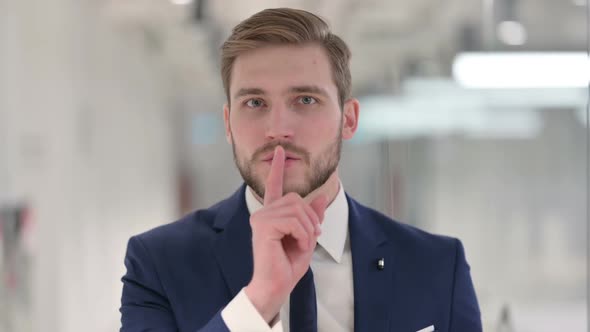Young Businessman Showing Quiet Sign Finger on Lips