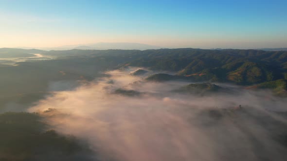 4K Scenic flight over beautiful mountain scape with bright sky and clouds