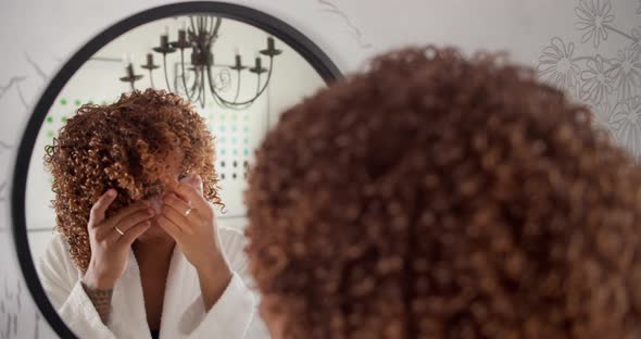 Happy Attractive African American Woman in Bathrobe Using Eyes Patches Looking at Mirror