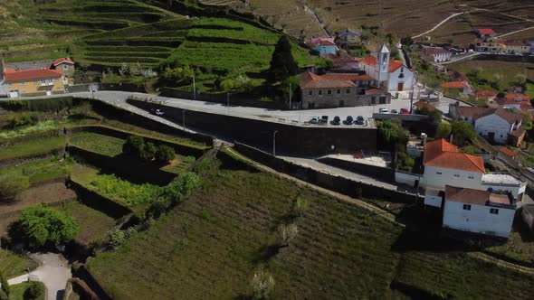 bird's-eye view of a small village square with parking at the church in the portuguese mountains nea
