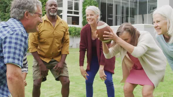 Animation of happy diverse female and male senior friends playing american football in garden