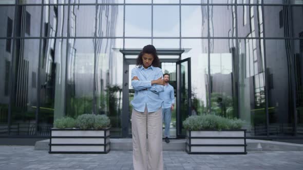 Upset Businesswoman Standing Holding Hands Crossed in Crowded Futuristic Street