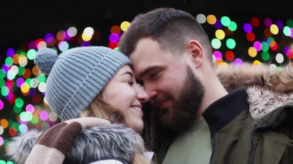 Beautiful couple, boyfriend and girlfriend are kissing on Christmas fair in Wroclaw, Poland