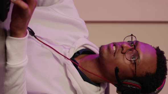 Closeup of African American Gamer with Gaming Headset Talking to Team Members in Multiplayer Game
