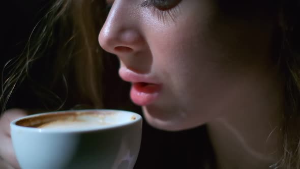 Closeup of Girl Drinking Coffee with Pleasure From a White Cup