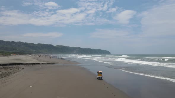 Aerial view of traditional horse cart ride on beach in Indonesia