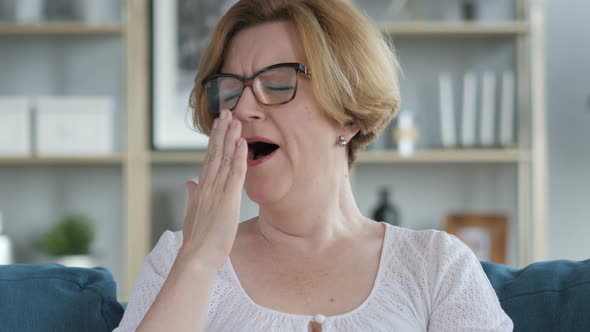 Yawning Tried Old Woman Sitting on Couch