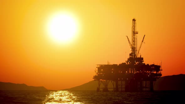 The sun setting behind an offshore oil platform