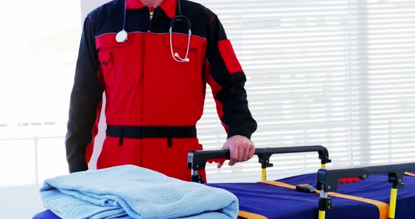 Portrait of male paramedic standing with stretcher