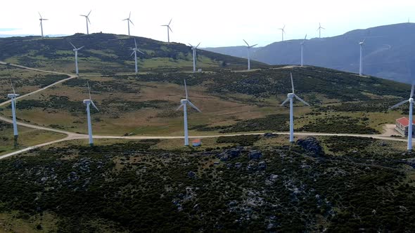 Aerial View Of Fast Spinning Windfarm Turbines In Hillside Of Galicia In Spain. Dolly Right