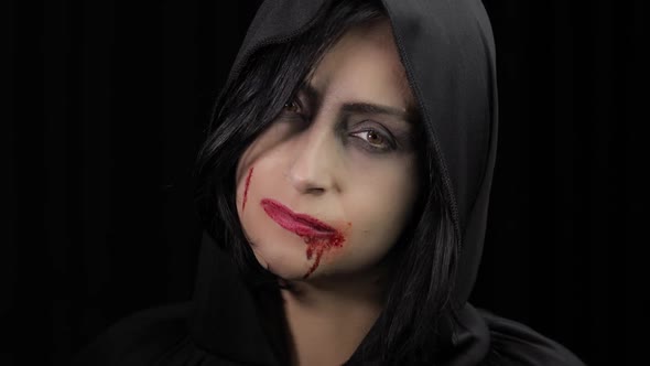 Vampire Halloween Makeup. Woman Portrait with Blood on Her Face.