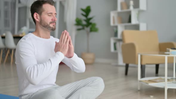 Man Meditating on Yoga Mat at Home