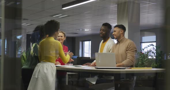 Happy diverse male and female business colleagues teaming up in office