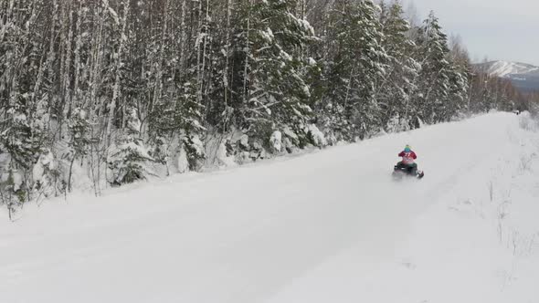 Men on snowmobile having fun and riding in winter scenery