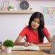 Portrait of Asian schoolgirl studying online making notes in copybook - VideoHive Item for Sale