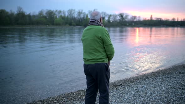 Thoughtful senior standing at riverside