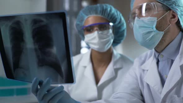 Doctors Studying X-Ray of Lungs in Lab, Analyzing and Discussing Diagnosis