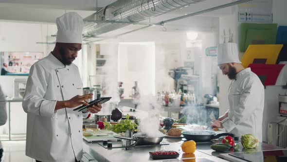 African American Cook Searching Gourmet Recipe on Digital Tablet
