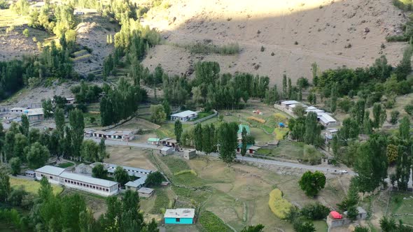 Aerial drone of a small Pakistani town in the mountains of Astore Valley Pakistan on a sunset aftern