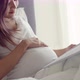 Asian pregnant wife reading a book to a child unborn baby. - VideoHive Item for Sale