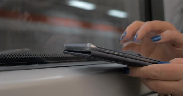 Woman Commuter Using Cellphone in Subway