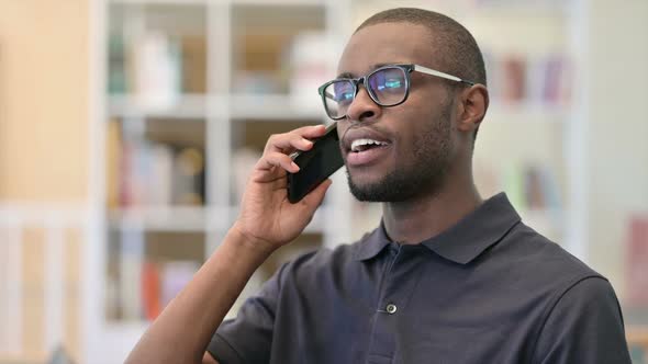 Portrait of Cheerful Young African Man Talking on Smartphone