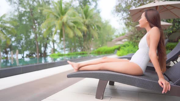 Young asian woman enjoy around outdoor swimming pool for leisure