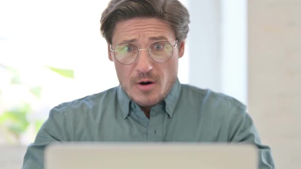 Portrait of Middle Aged Man Reacting to Loss Laptop