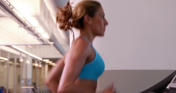 Super fit Woman Running on the Treadmill