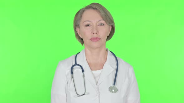 Serious Old Female Doctor on Green Background