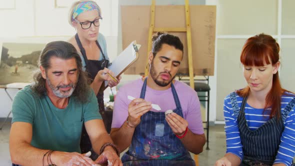 Drawing teacher assisting artist in pottery 4k